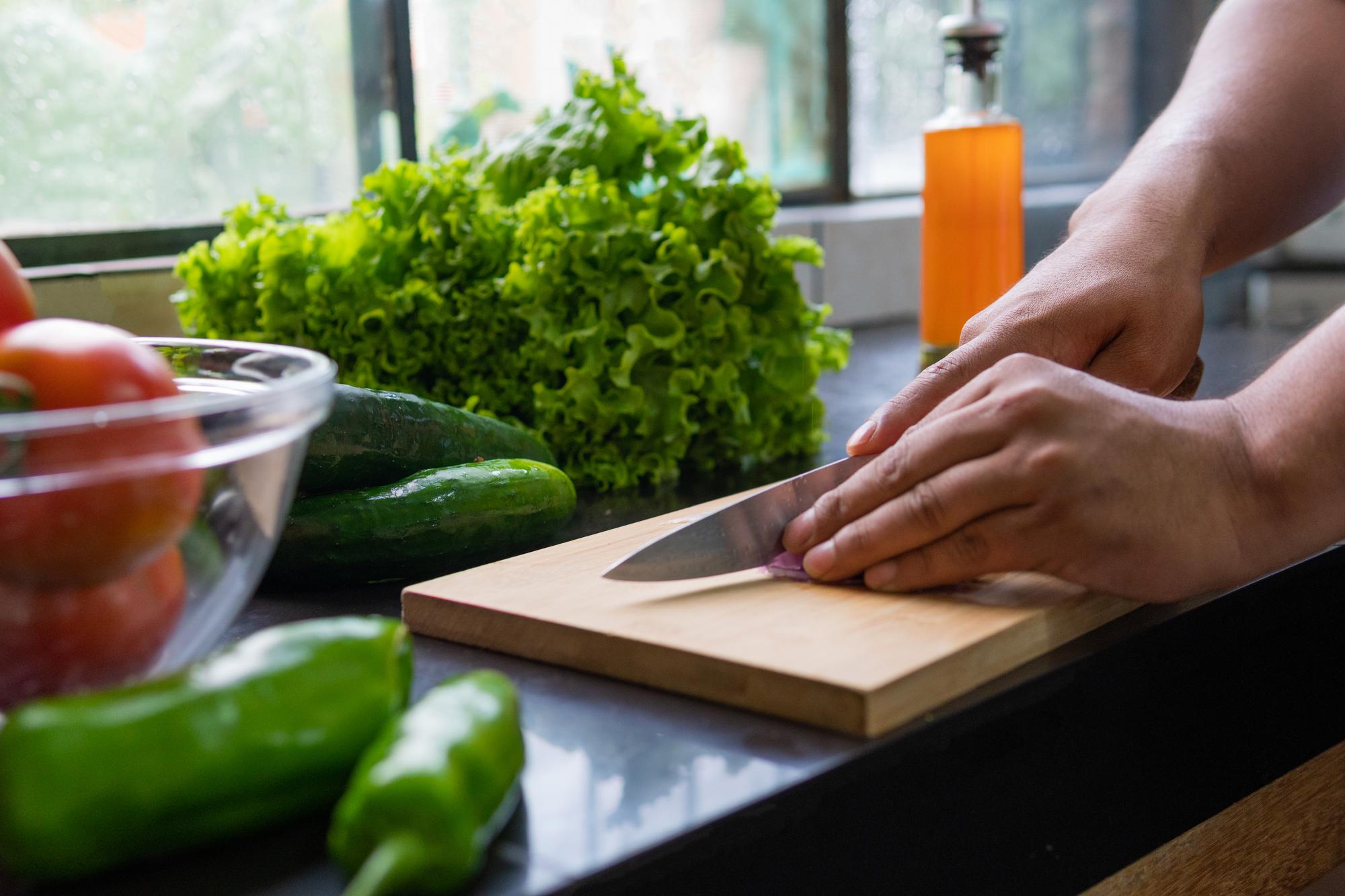 Hands chopping herbs over cutting board