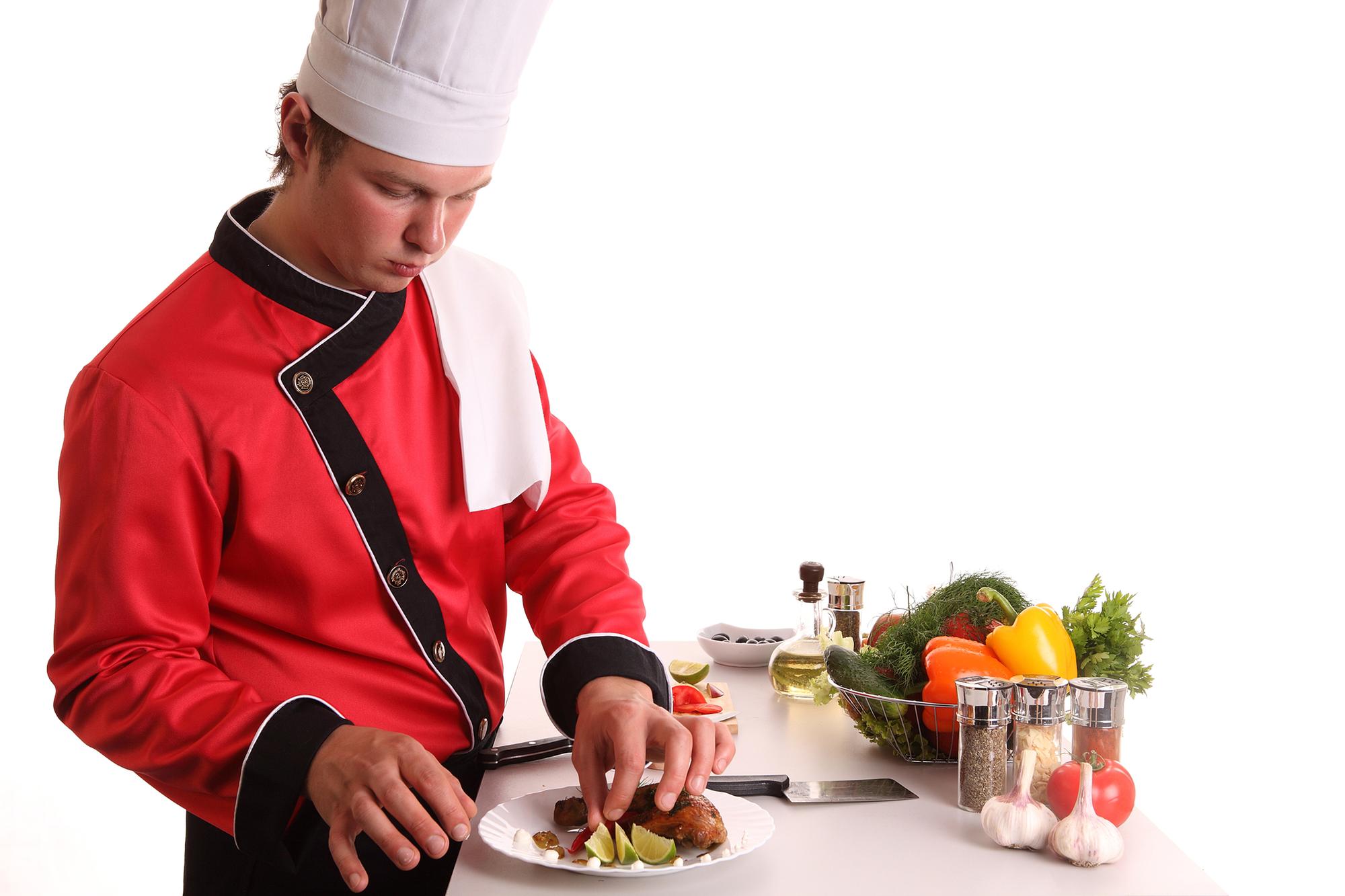 Chef demonstrating plating on a modern stove